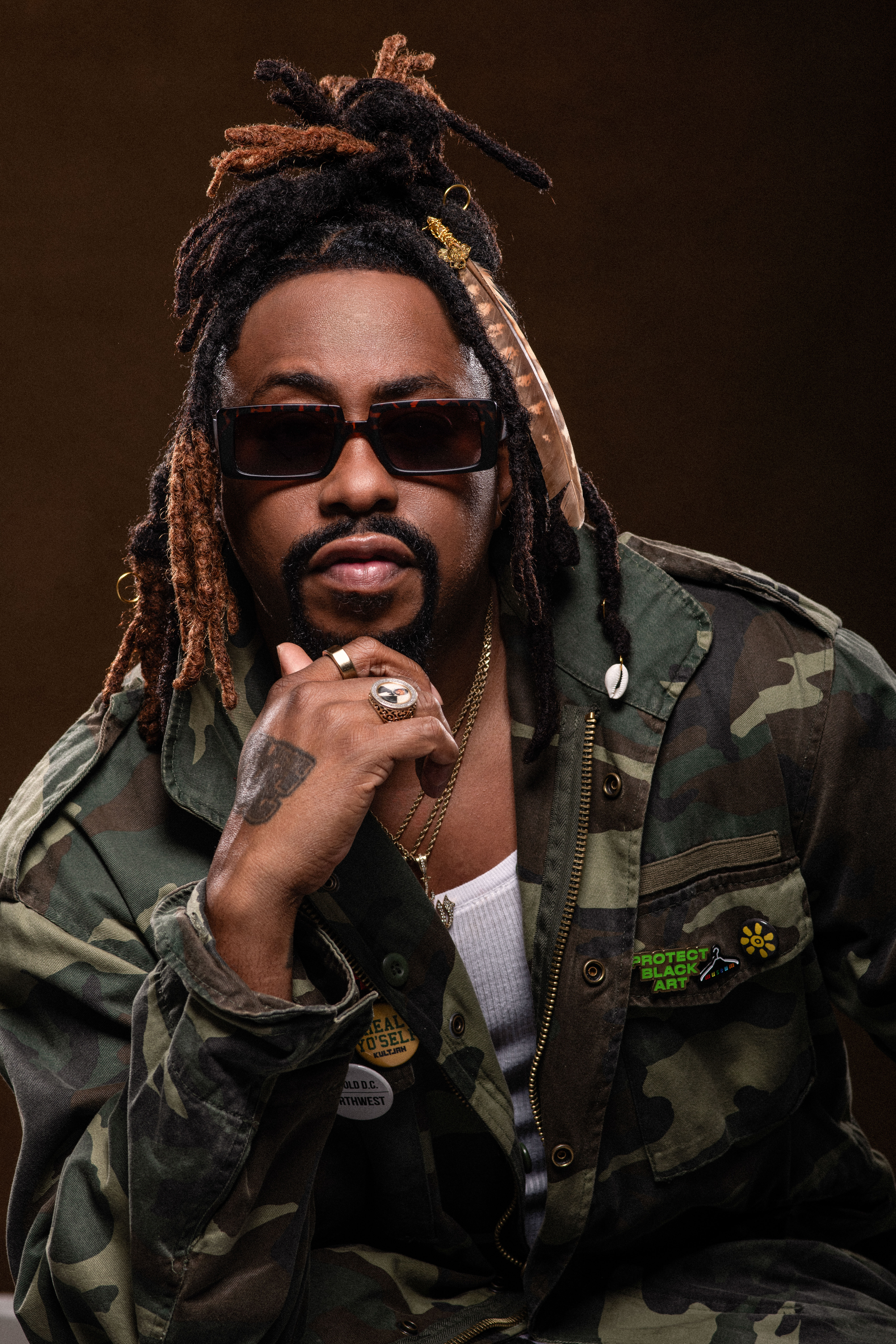 Raheem DeVaughn in a camo jacket, studio portrait