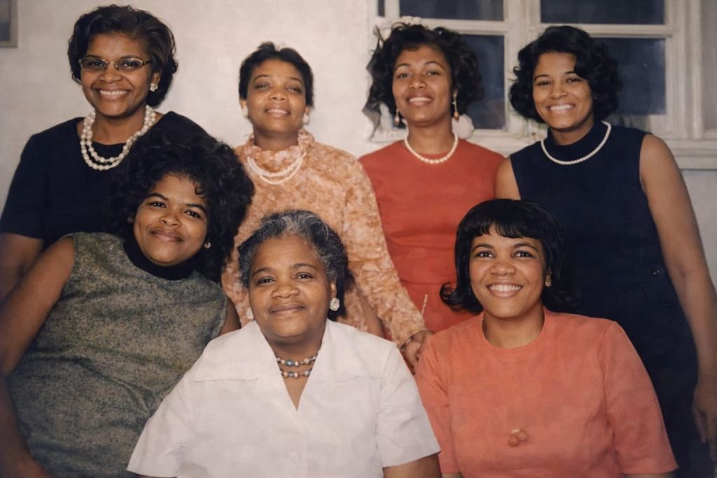 Faded sepia photo of eight women in a family group, restored