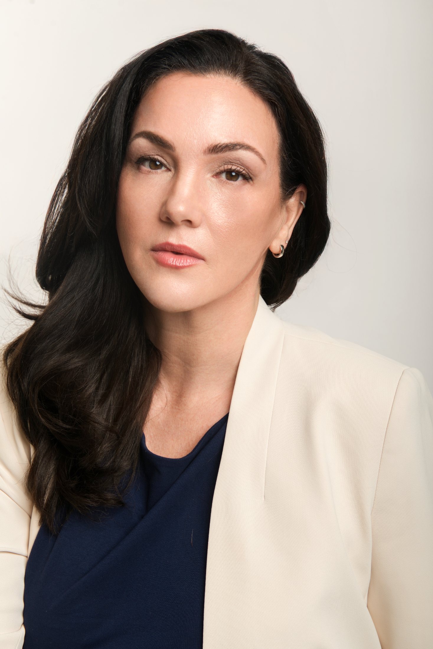 Executive headshot of a woman in a cream blazer