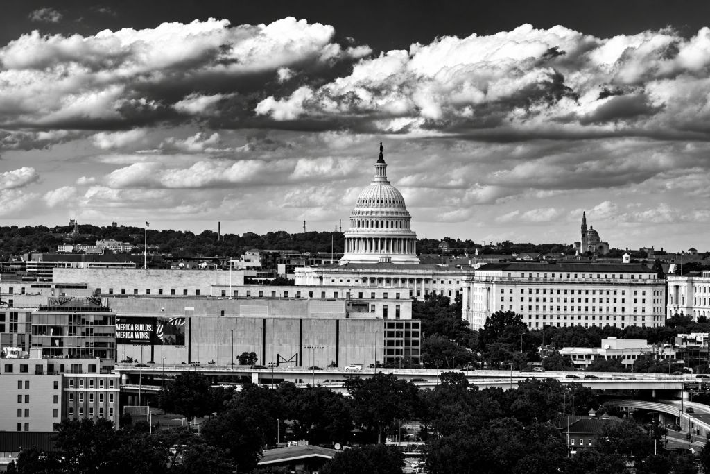 Black-and-white photograph of the U.S. Capitol under dramatic clouds